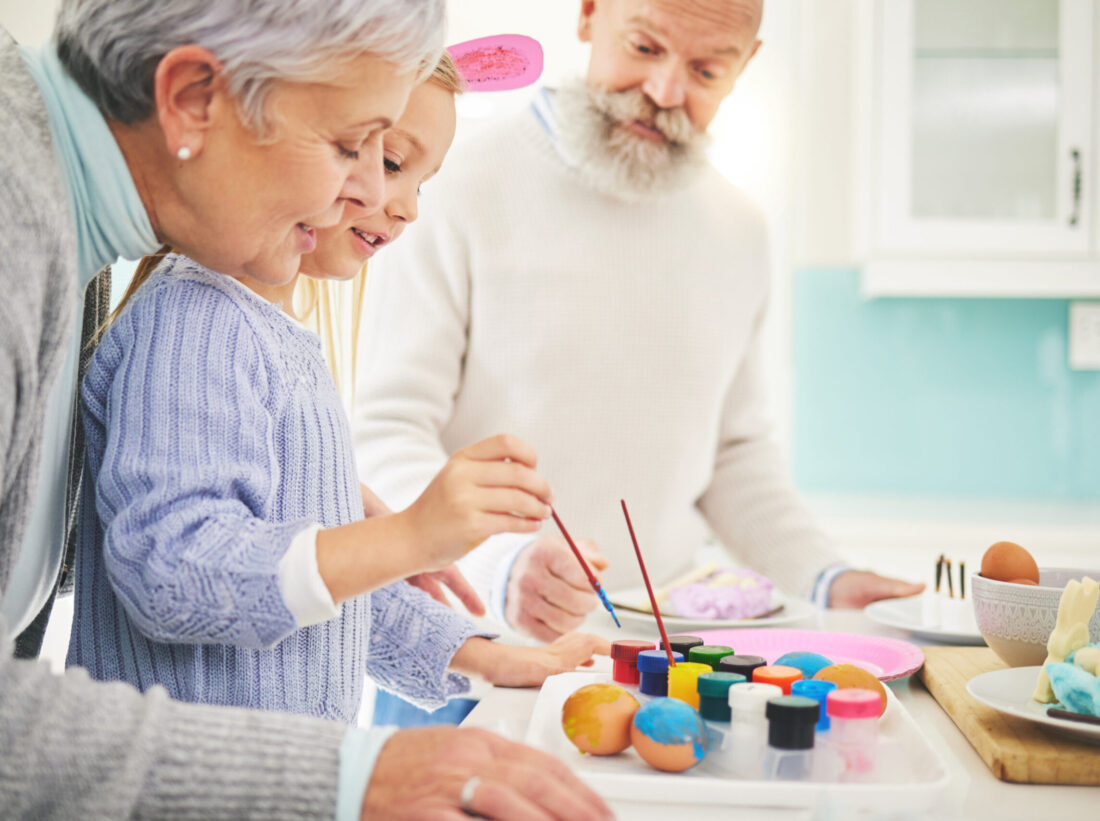 Young girl painting eggs with grandparents Young girl painting eggs with grandparents