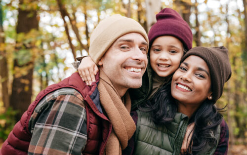 Family close up portrait in warm clothes at the park