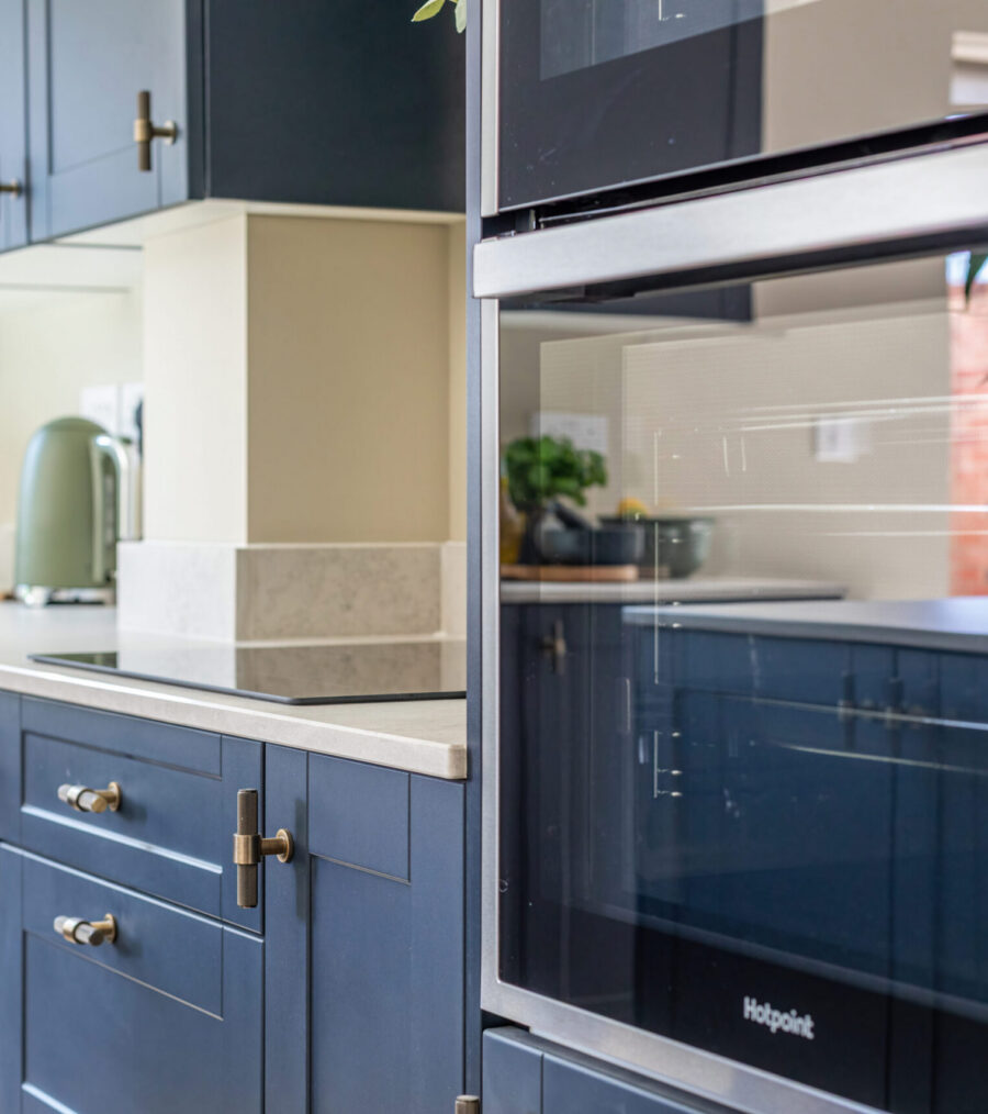 An integrated oven in a blue kitchen