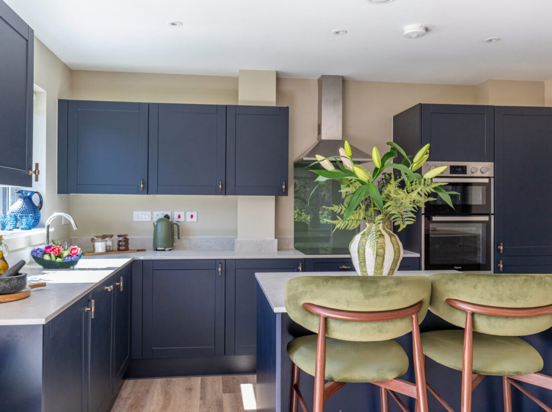 A large styled show home kitchen with blue cabinets