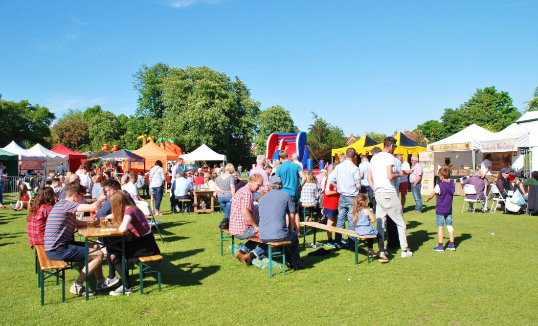 Families sat at picnic tables at an outdoor community festival